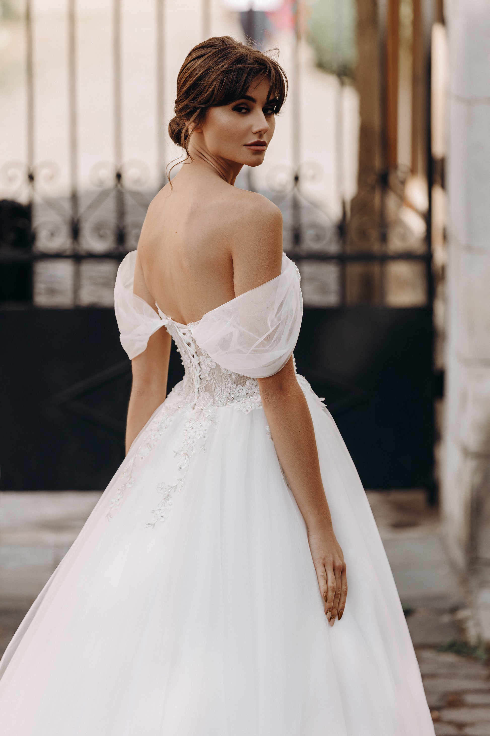 Bride in floral lace bodice with off-shoulder sleeves and soft tulle overlay