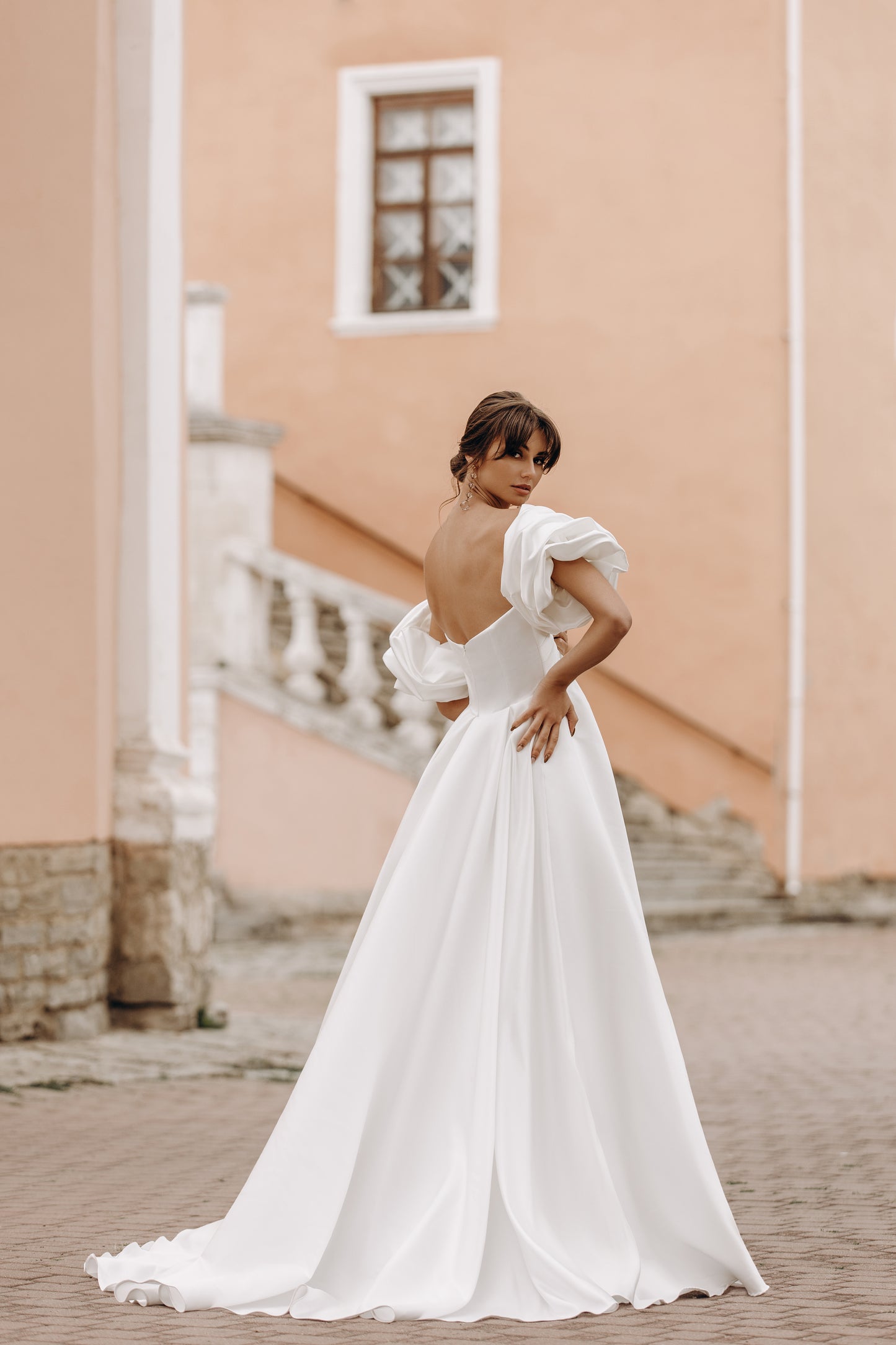 Flowing satin gown with puff sleeves and open back
