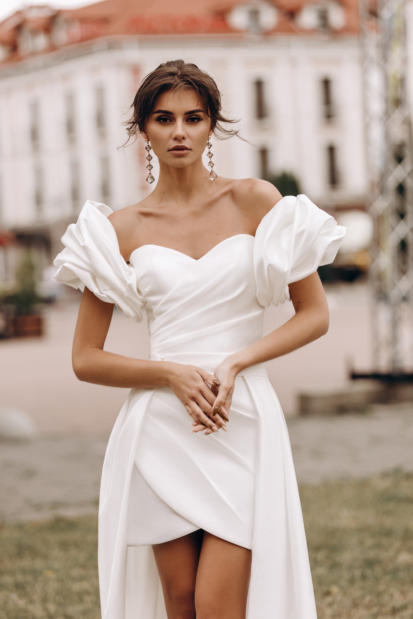 Bride’s mini dress with fitted waist, showing voluminous sleeves