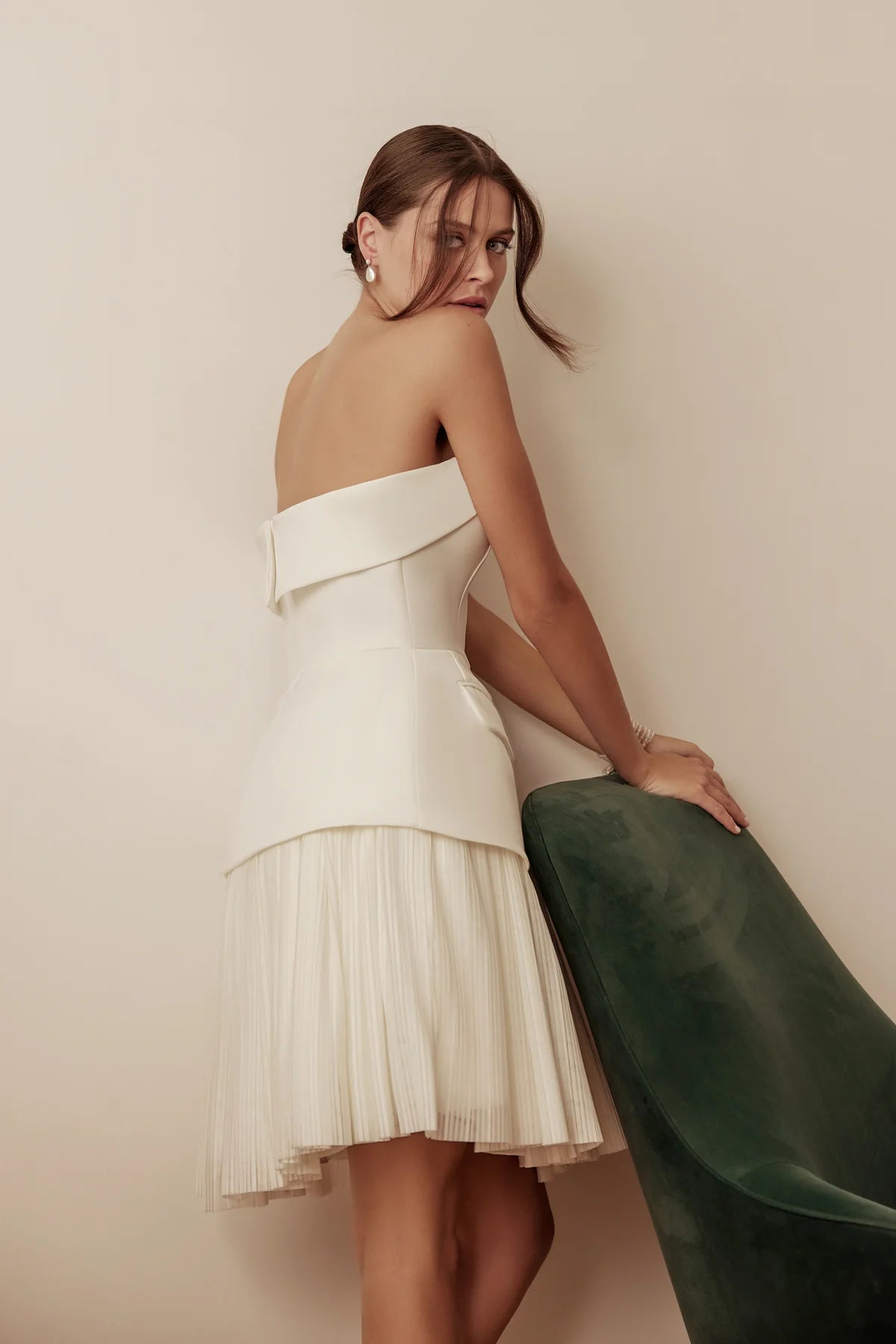 Bride standing in modern strapless A-line wedding dress with a flared skirt and playful pockets