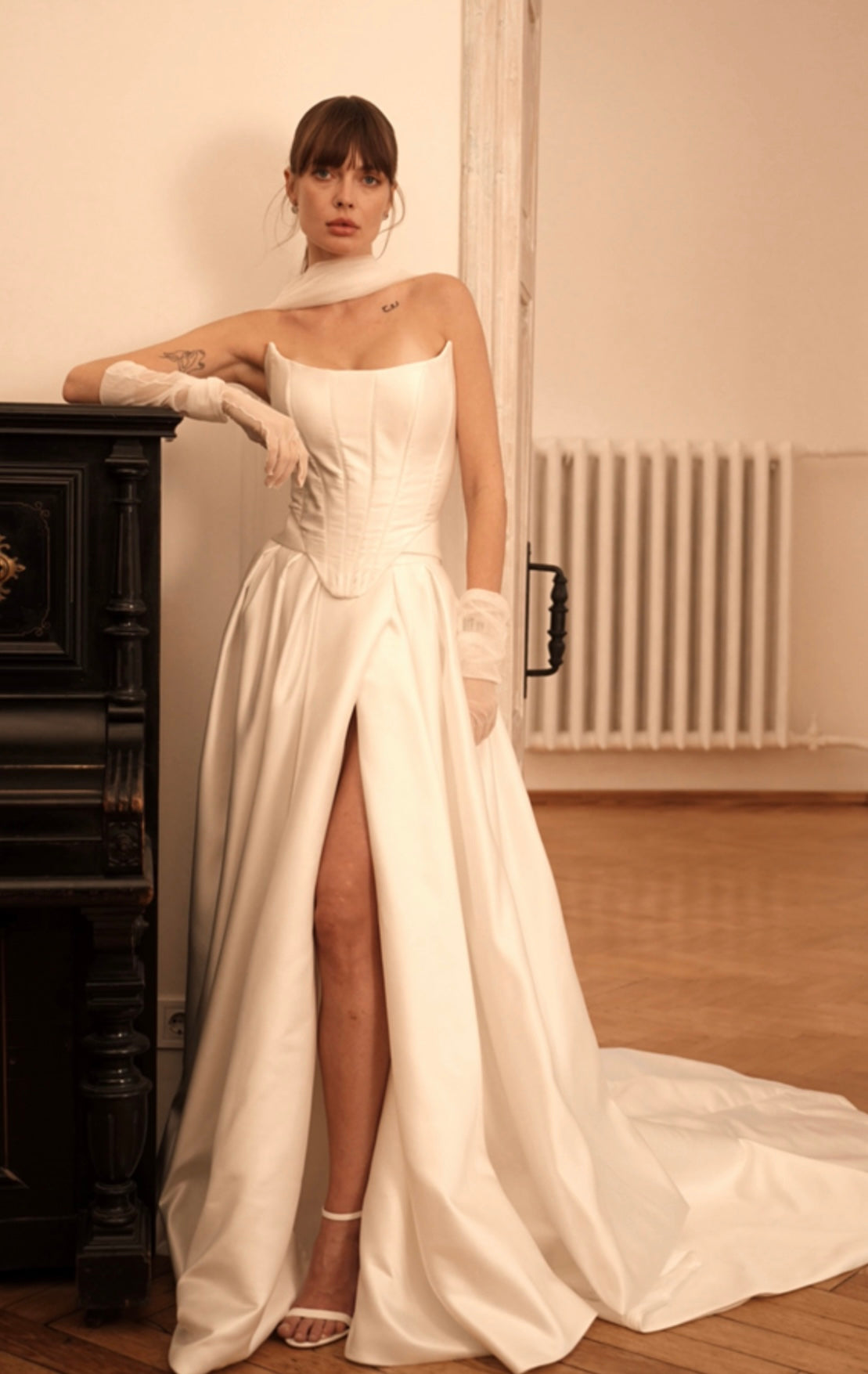 Bride showing off the flowing skirt with high slit and fitted bodice