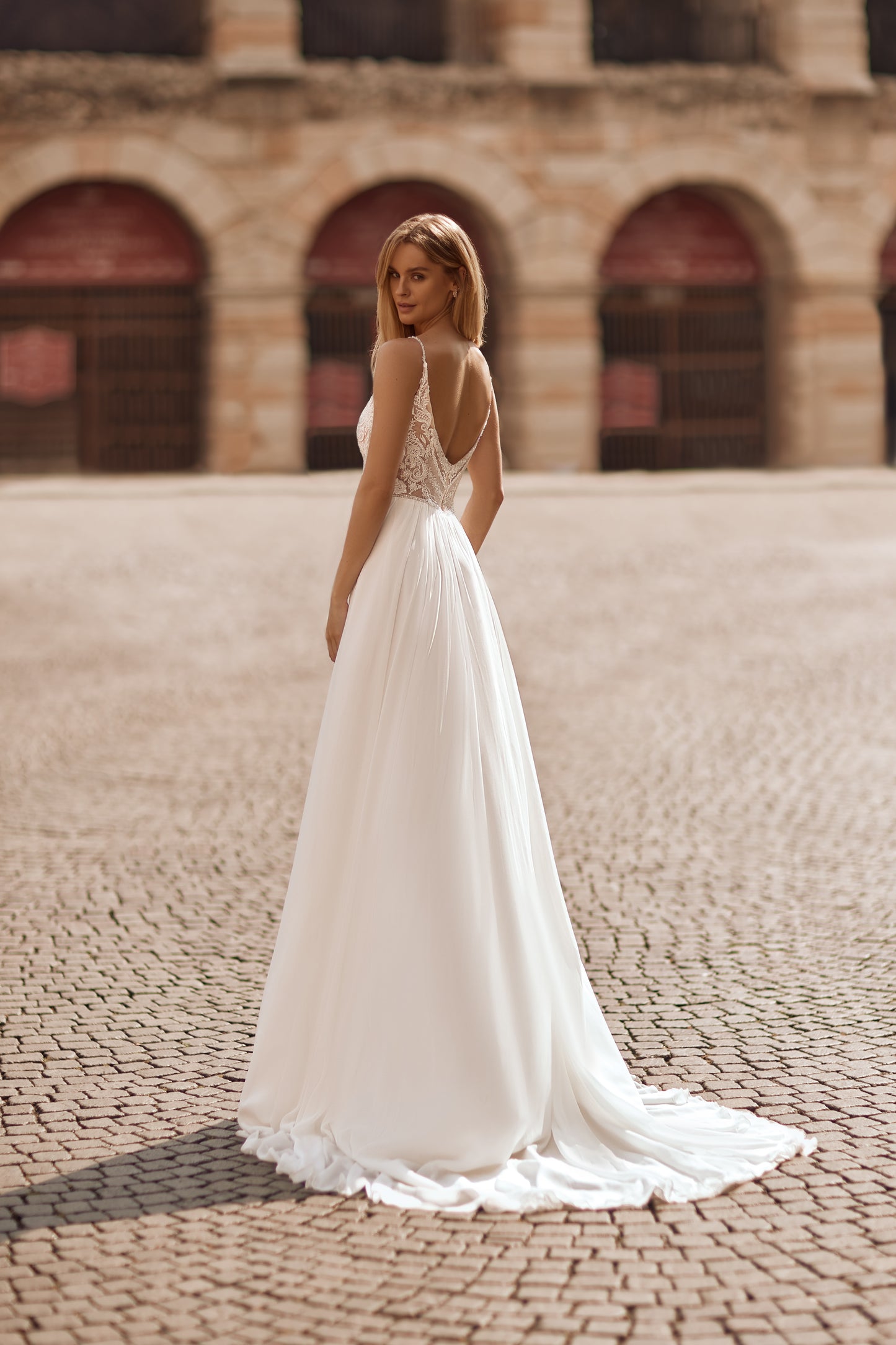Elegant bridal gown with shimmering bodice, leg slits, and detachable cape