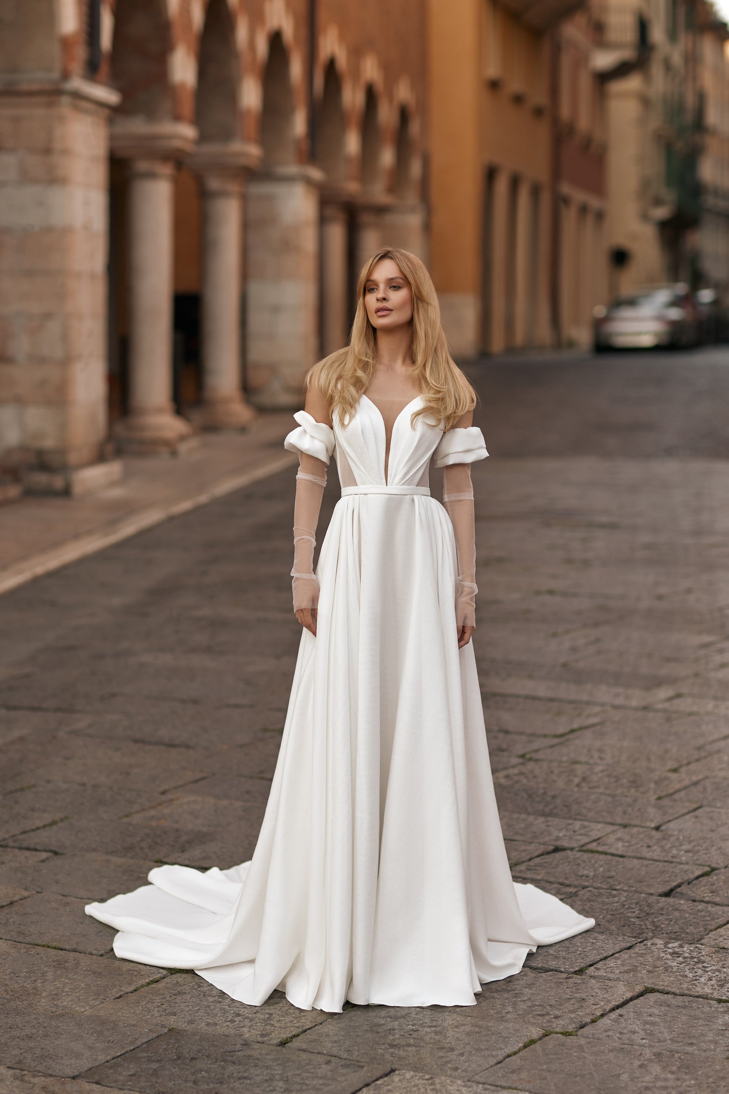 Bride in ivory gown with sheer bodice panels, flowing skirt, and thigh-high slit
