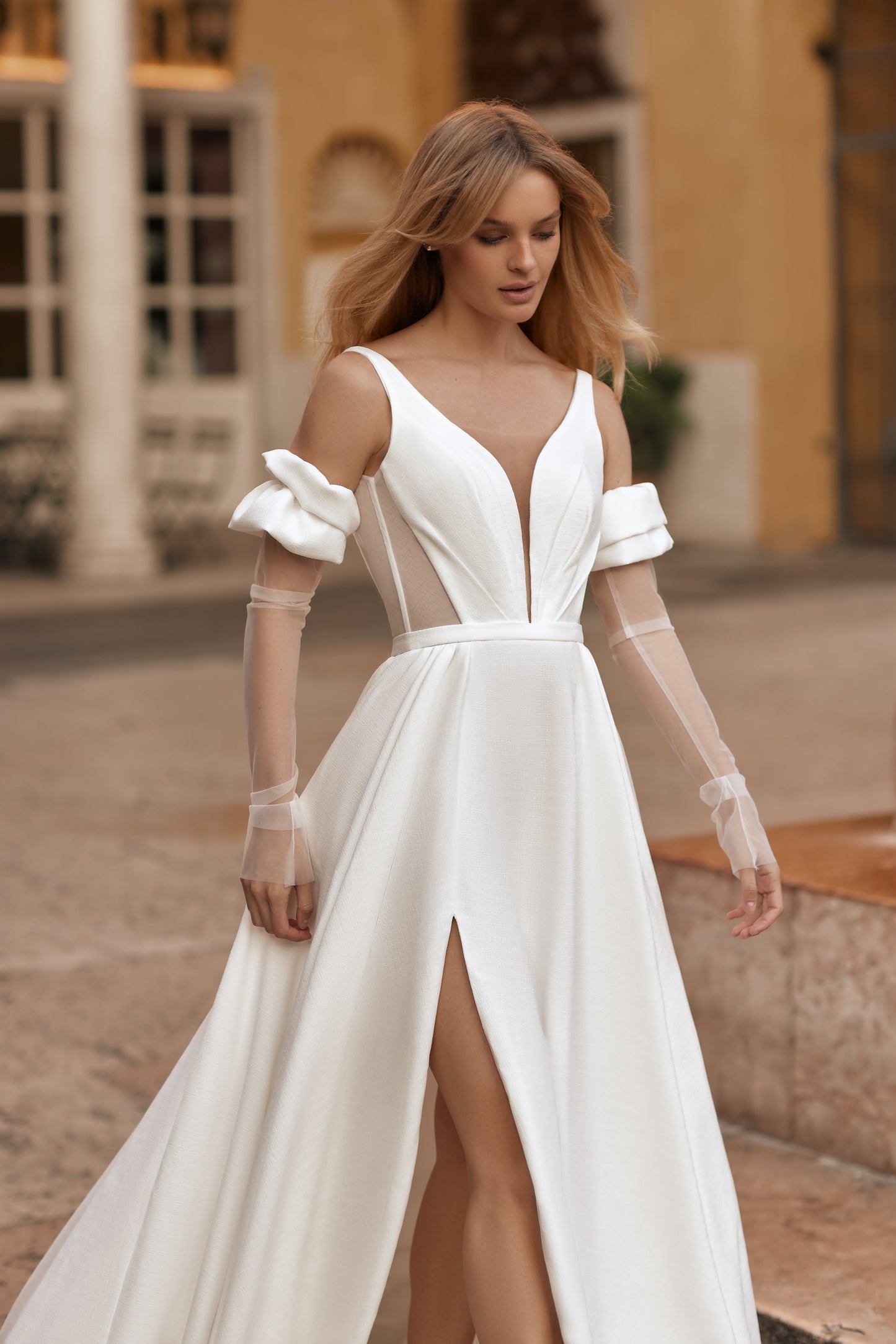Bride wearing elegant ivory gown with sheer inserts and soft, feminine details