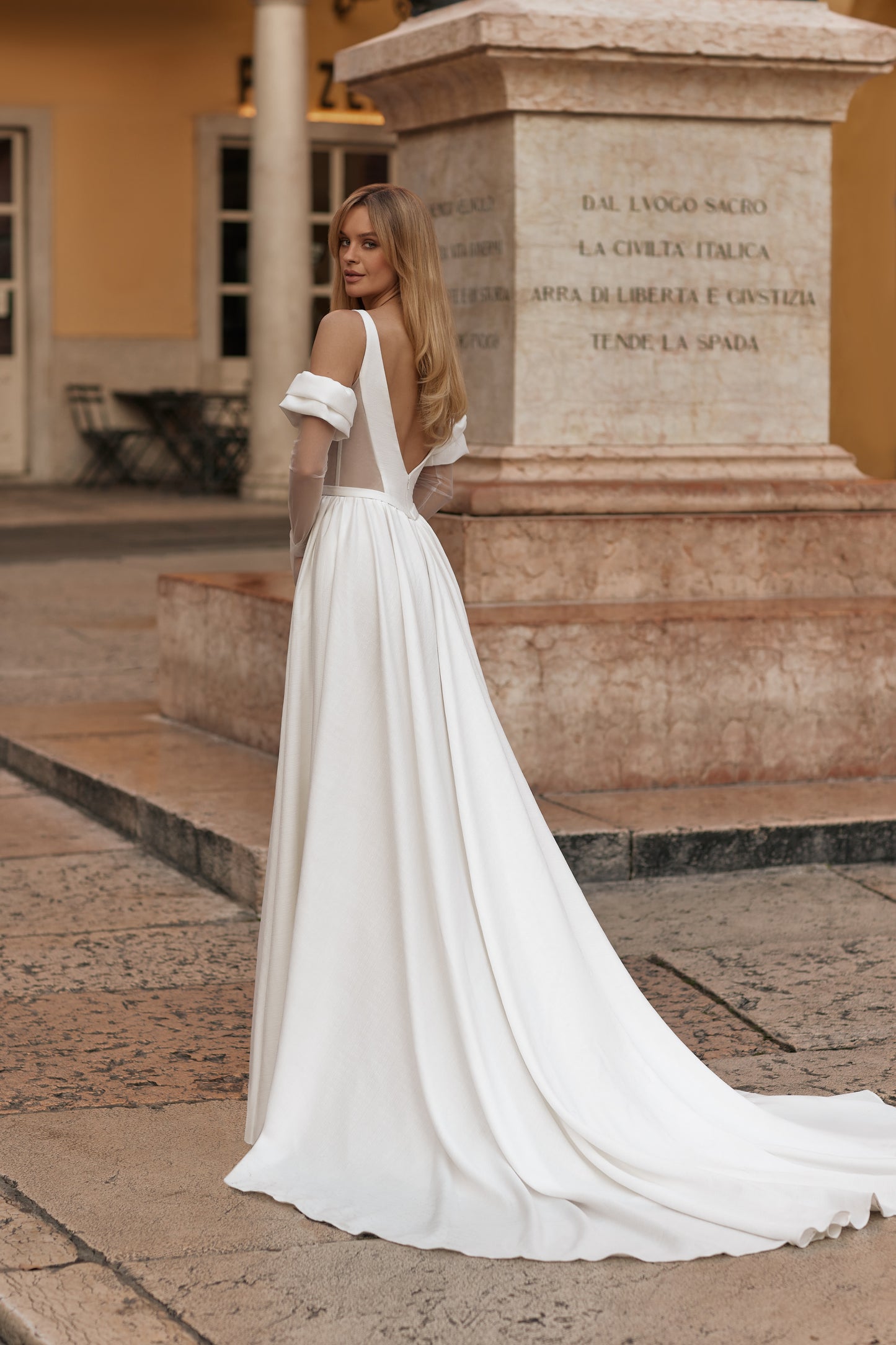 Wedding dress with open back, delicate sleeves, and floor-length train