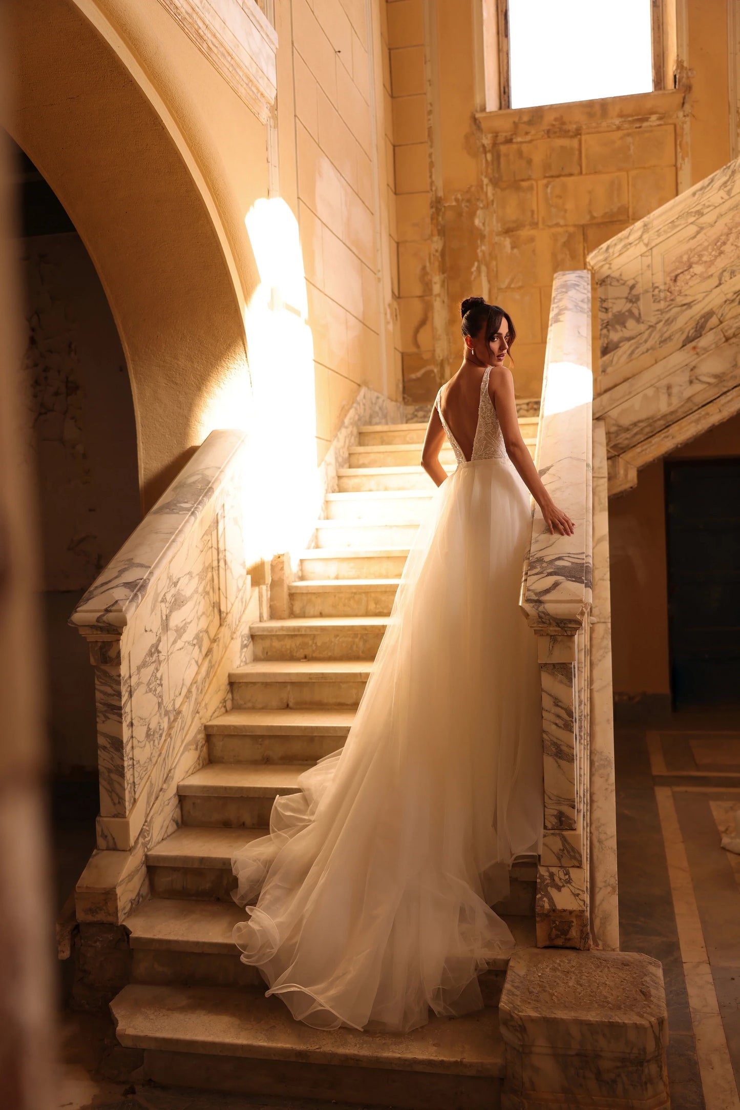 Elegant bridal gown with sheer layers and romantic low back design