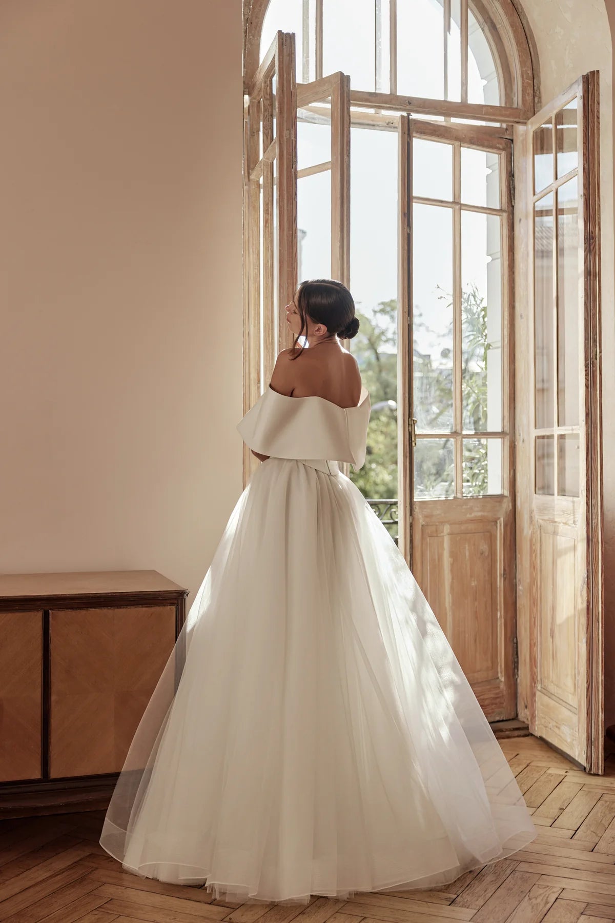 Bride wearing voluminous skirt with fitted bodice, captured in profile