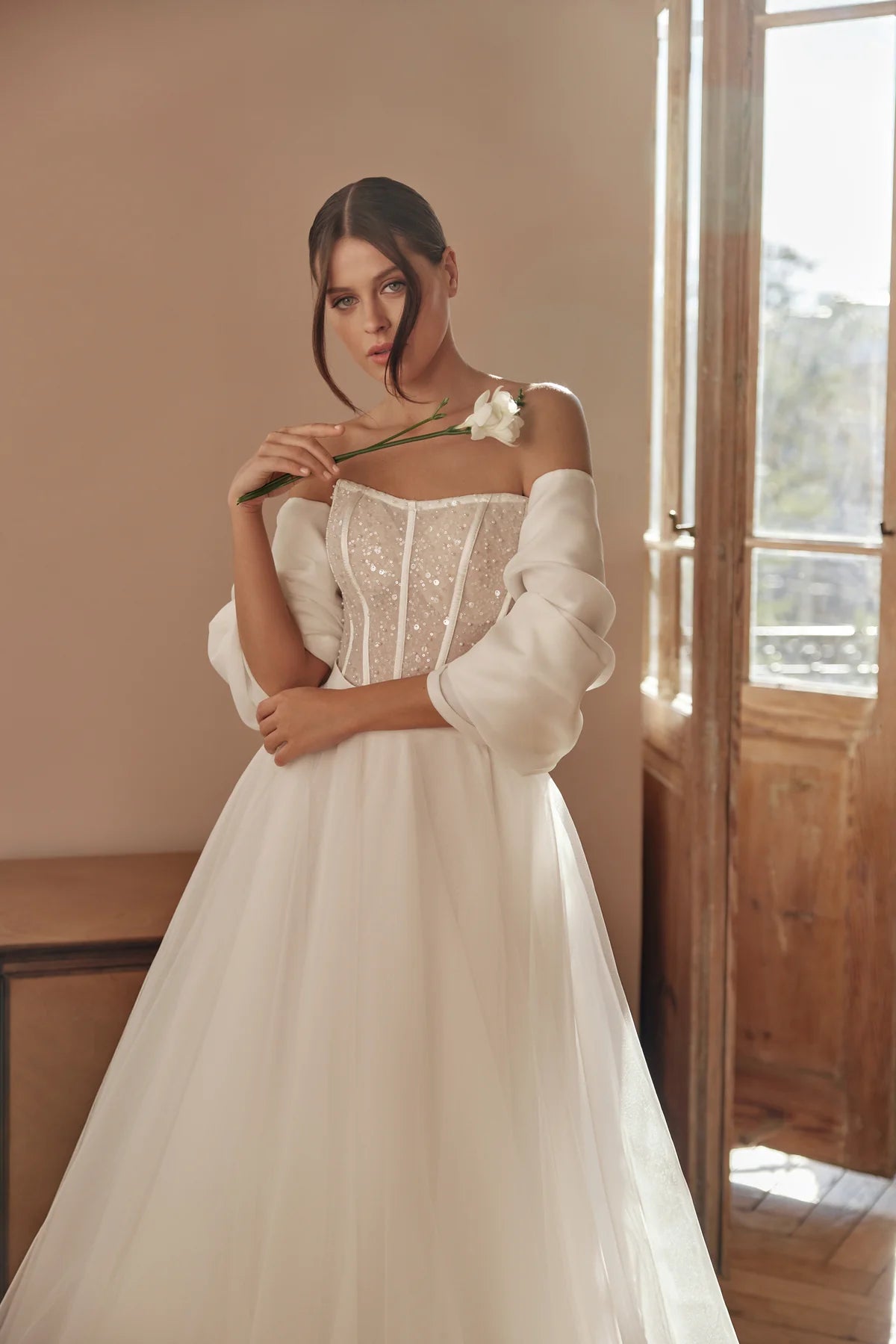 Bride holding the skirt of the gown, highlighting its sparkle and romantic silhouette