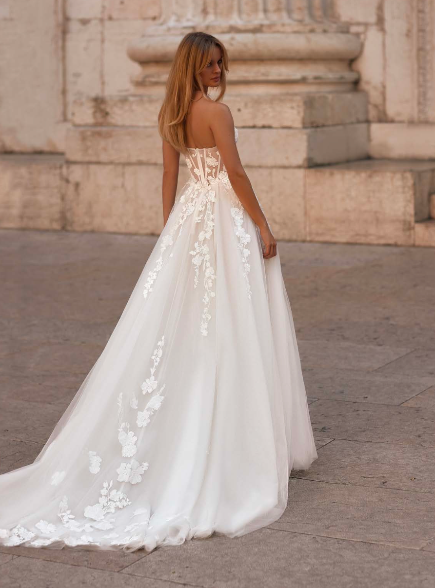 Elegant gown with fitted corset, floral lace details, and sheer transparent sleeves