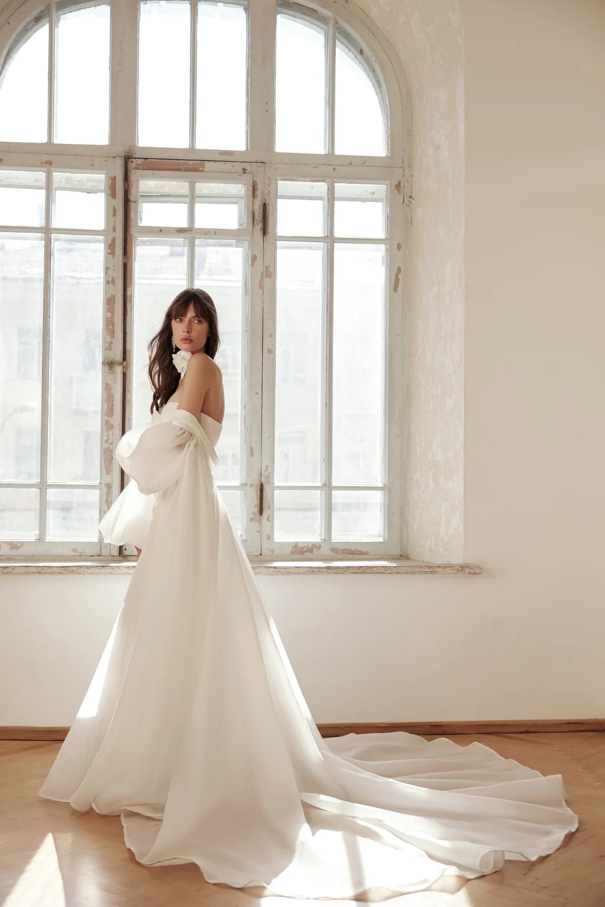 Elegant back view of the Klein dress featuring a structured bodice, puff sleeves, and a long, dramatic satin train.