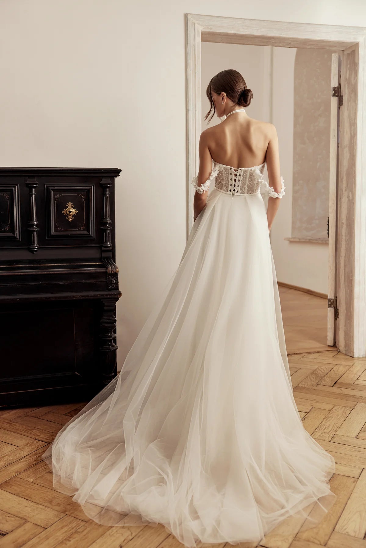 Bride in an ivory A-line dress with off-shoulder design and floral lace, flowing skirt captured in motion.