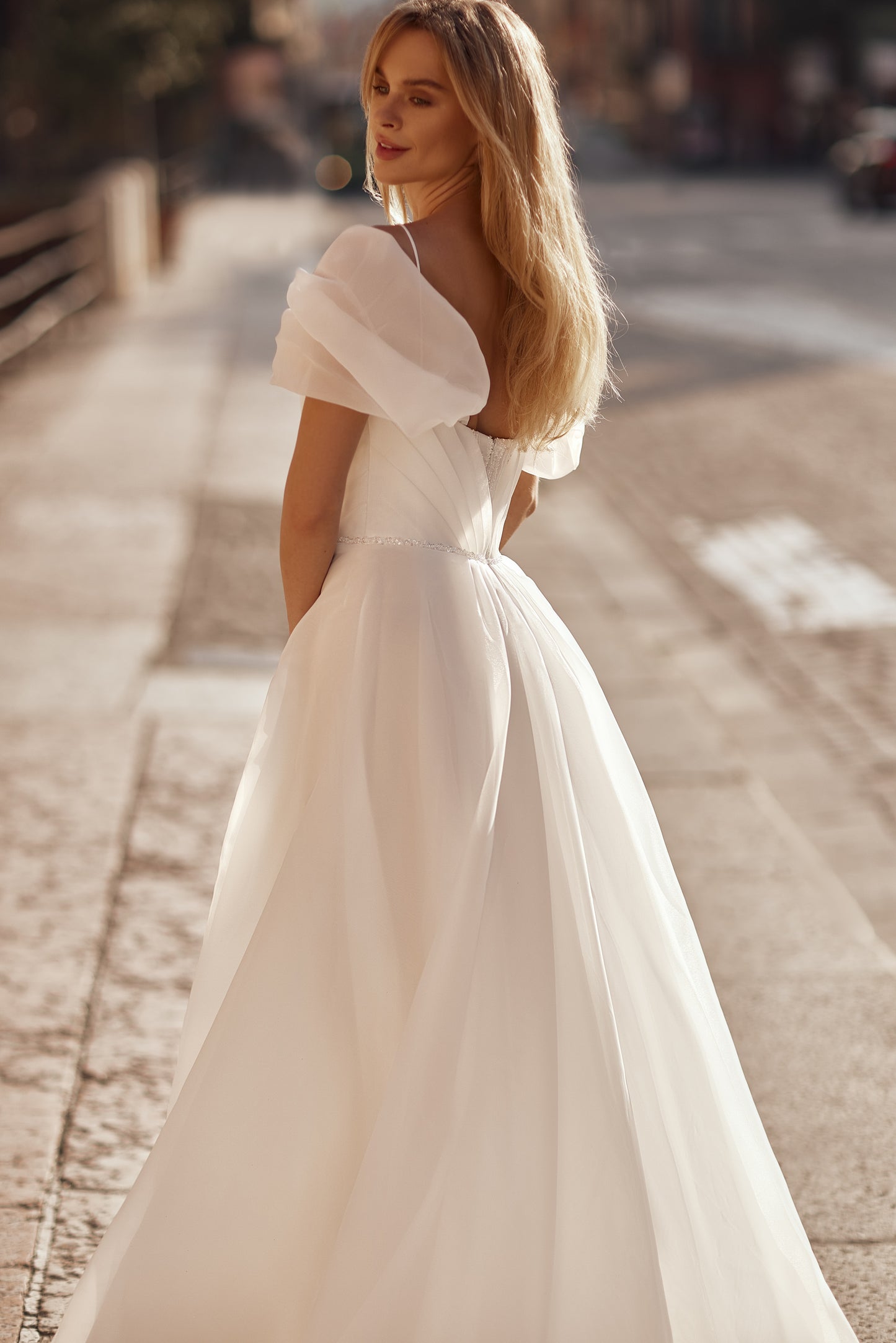 Flowing wedding gown with delicate shimmer, statement sleeves, and a romantic train