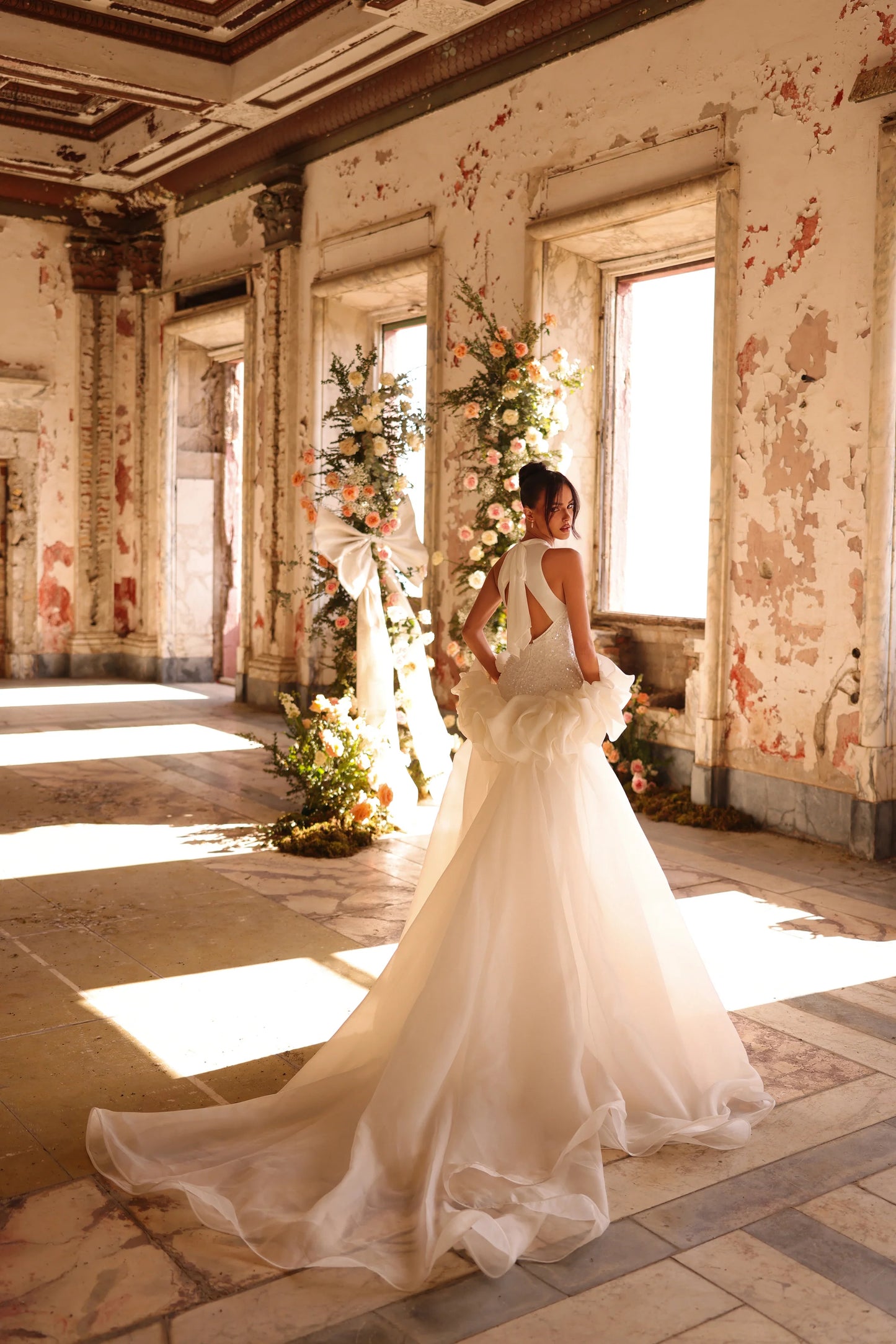 Elegant bridal gown with layered tulle and shimmering fabric from behind