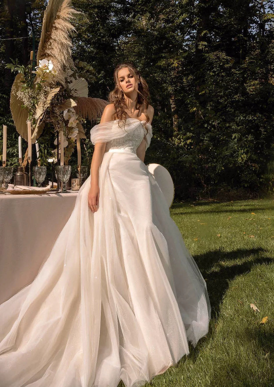 Bride wearing a luxurious tulle gown with sequins, a satin corset with glitter lace, and a long, flowing train.
