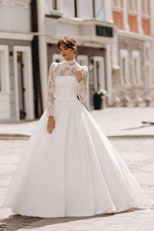 Bride wearing classic ball gown with long lace sleeves and full skirt