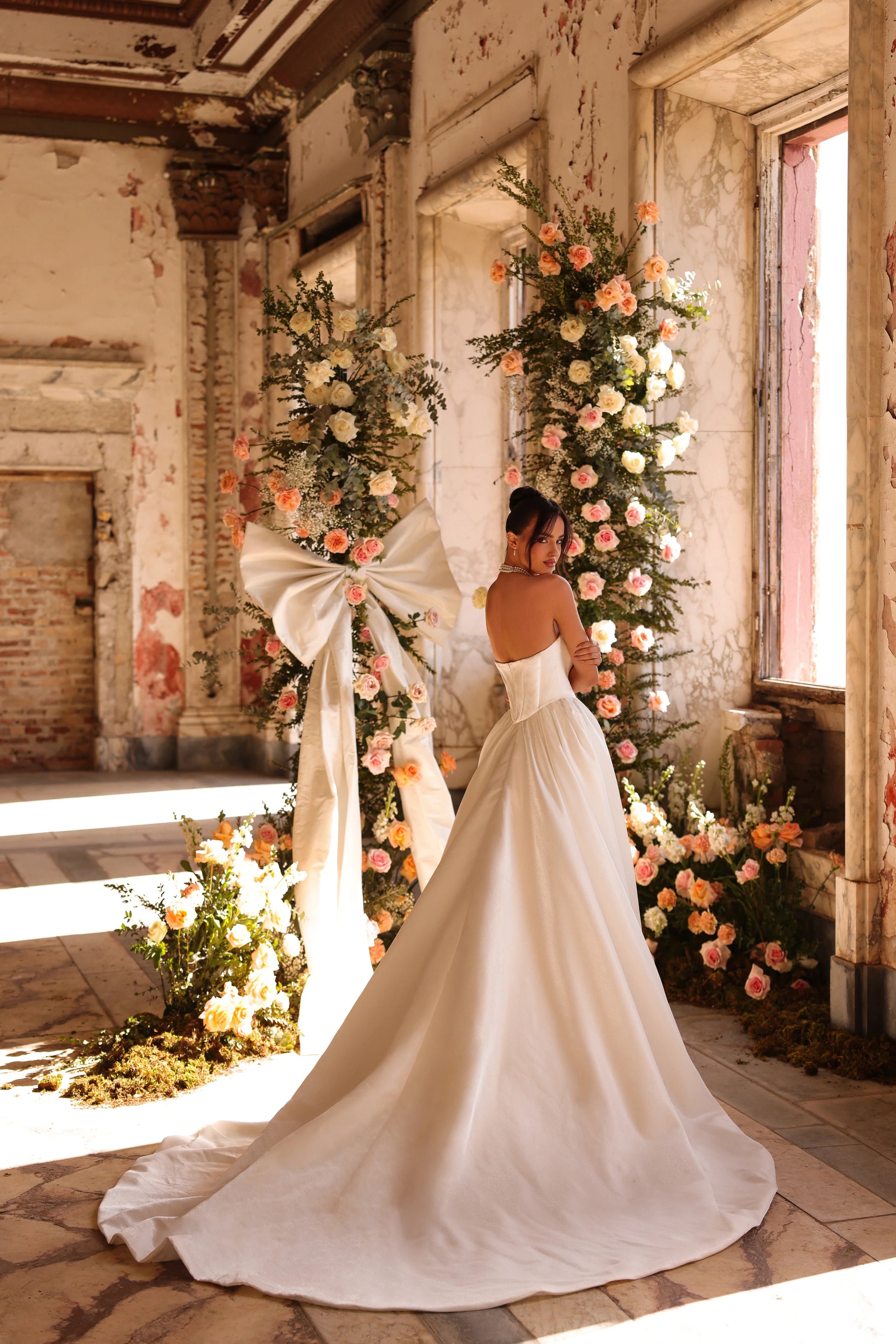 Minimalist wedding gown with romantic train cascading from fitted silhouette