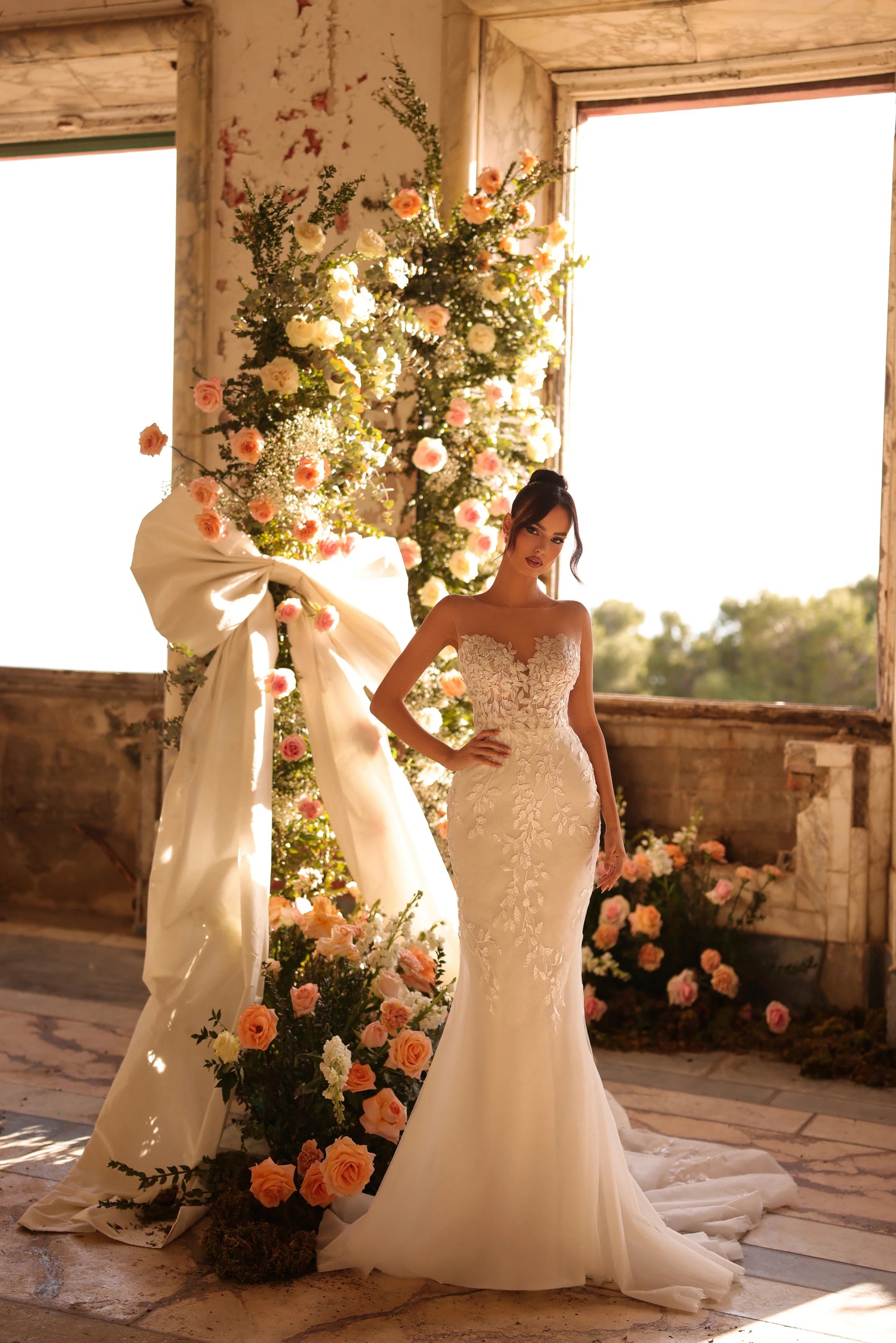 Bride in sleek silhouette gown with floral illusion corset and elegant overskirt