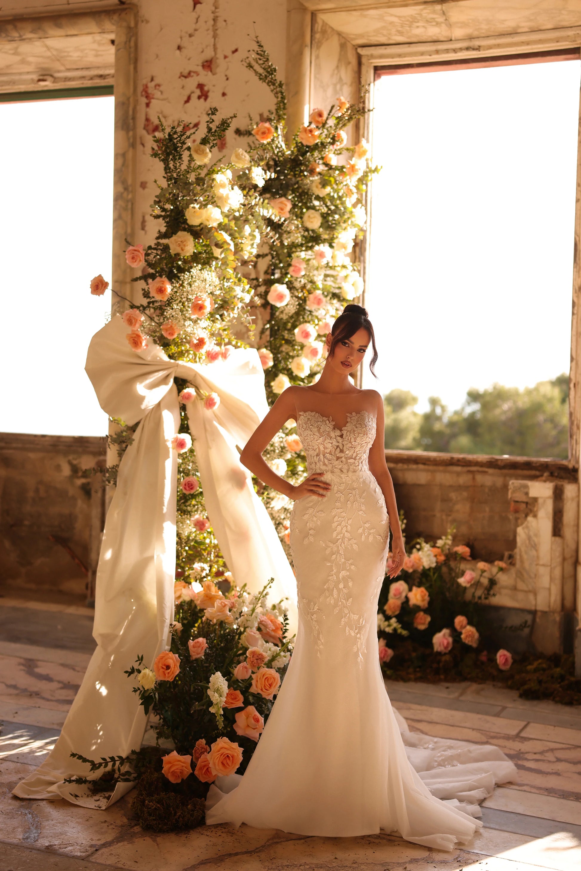Bride in sleek silhouette gown with floral illusion corset and elegant overskirt