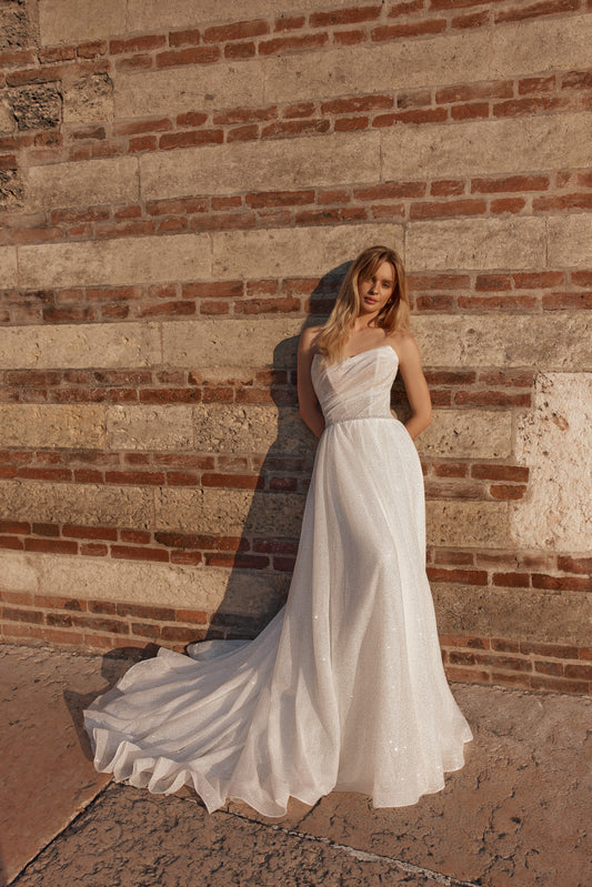 Bride in strapless wedding gown with fitted bodice and flowing skirt