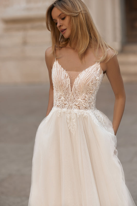 Bride in delicate floral lace wedding gown with tulle skirt and soft train