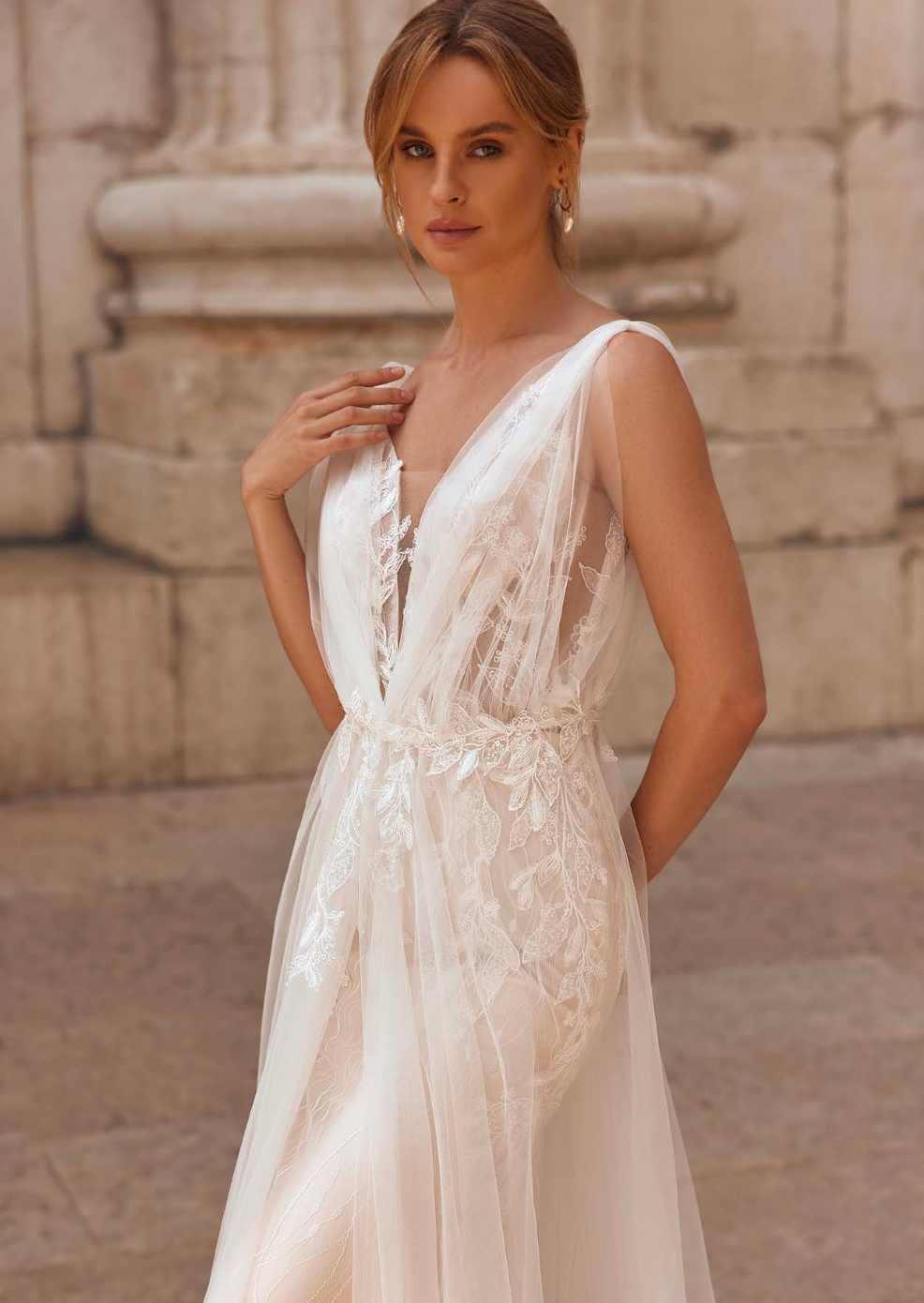 Bride wearing deep V-neck embroidered wedding gown with subtle sparkle