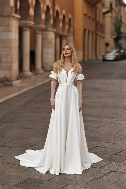 Bride in ivory gown with sheer bodice panels, flowing skirt, and thigh-high slit