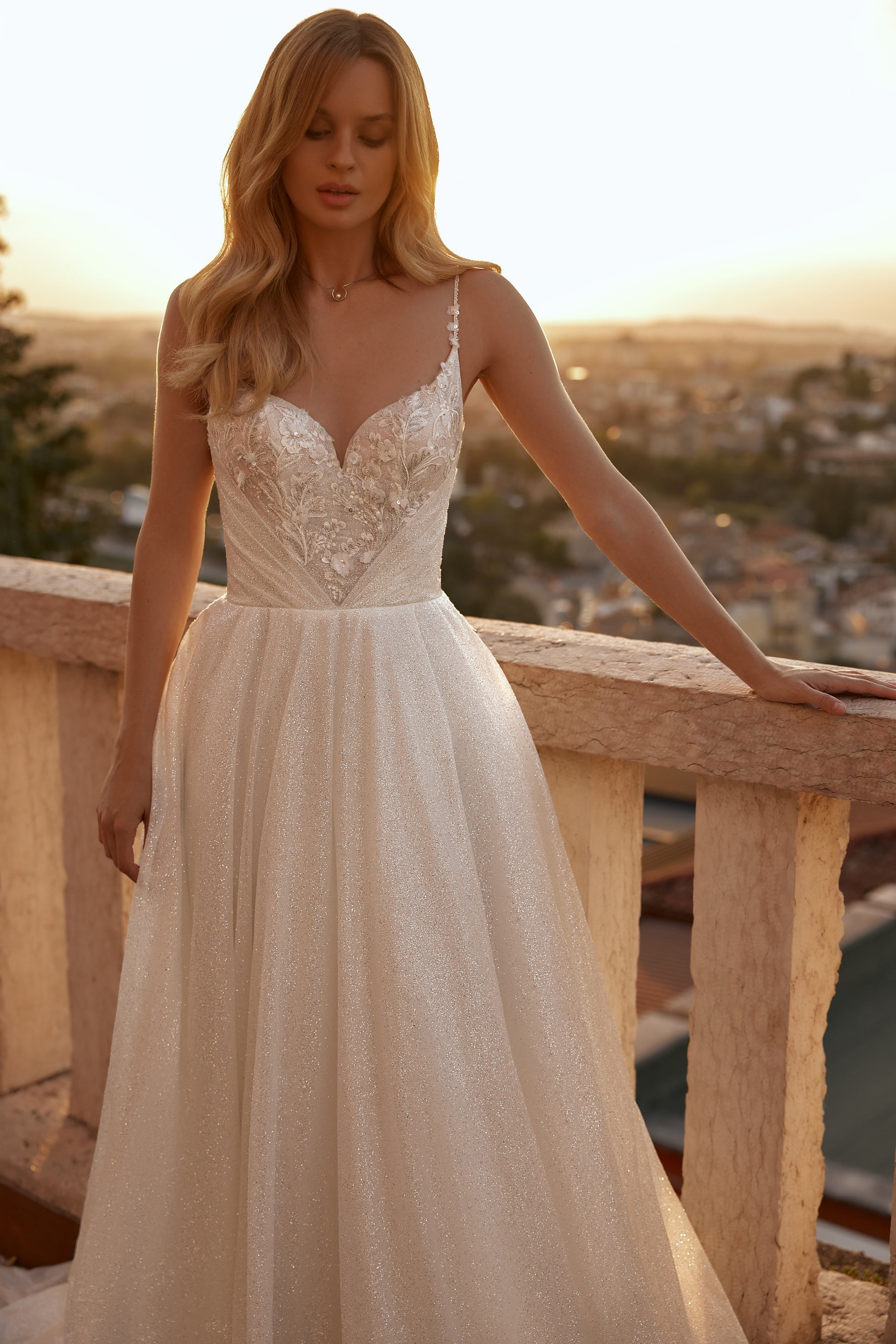 Bride in ivory gown with sweetheart neckline, floral appliqués, and flowing skirt