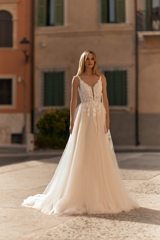 Bride in nude-toned mesh gown with 3D floral lace details and flowing skirt