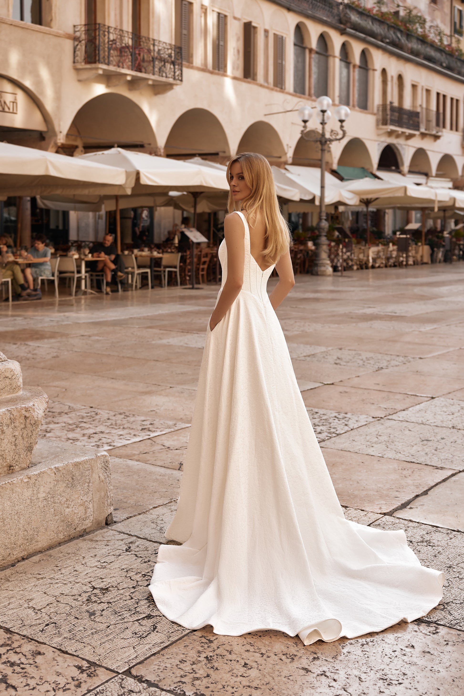 Elegant ivory gown with open back, subtle embossed pattern, and full skirt