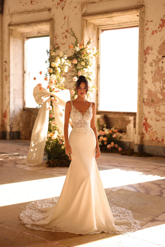 Bride in sleek fitted gown with lace bodice and long crepe skirt