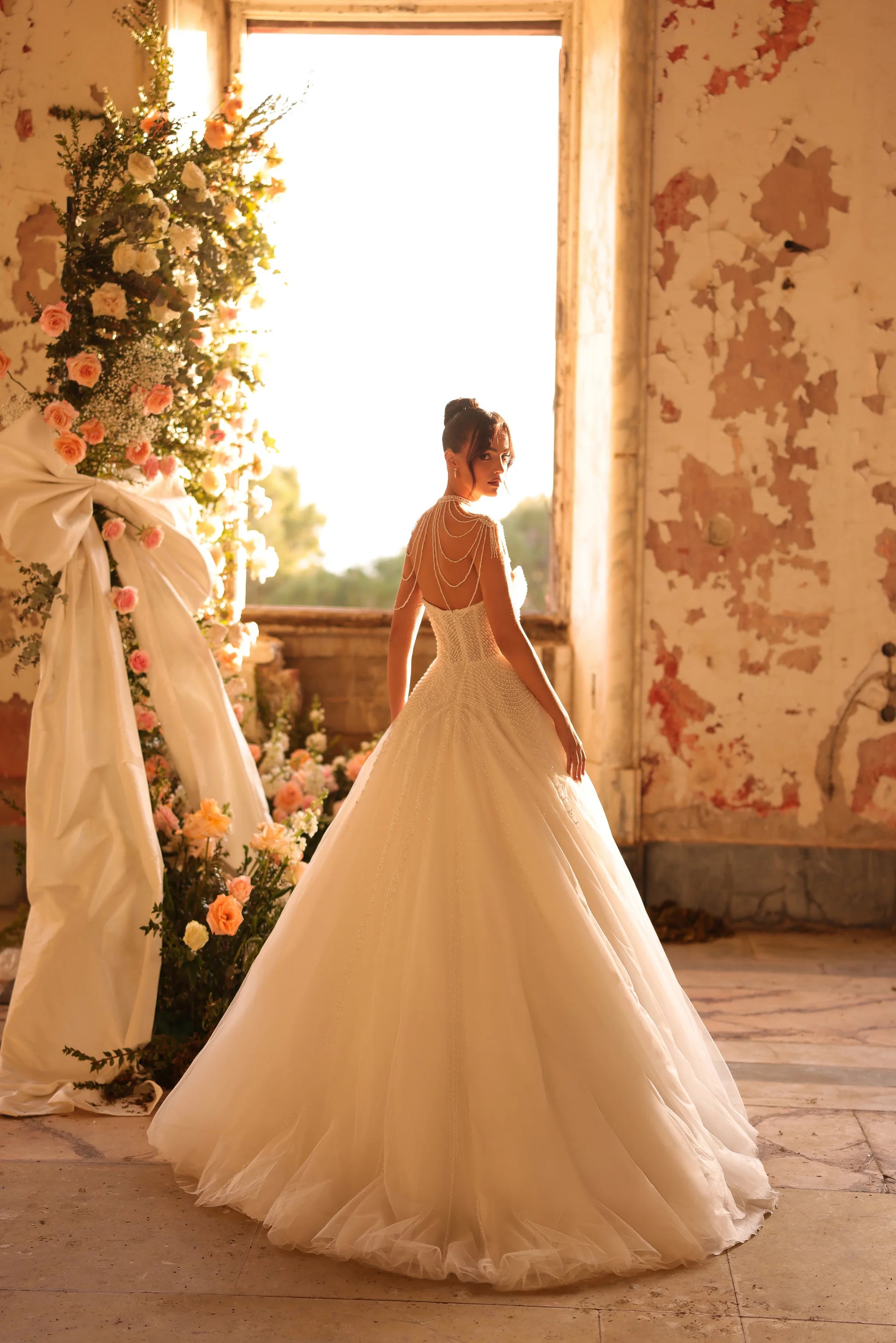Classic bridal look featuring pearl details and soft, flowing train