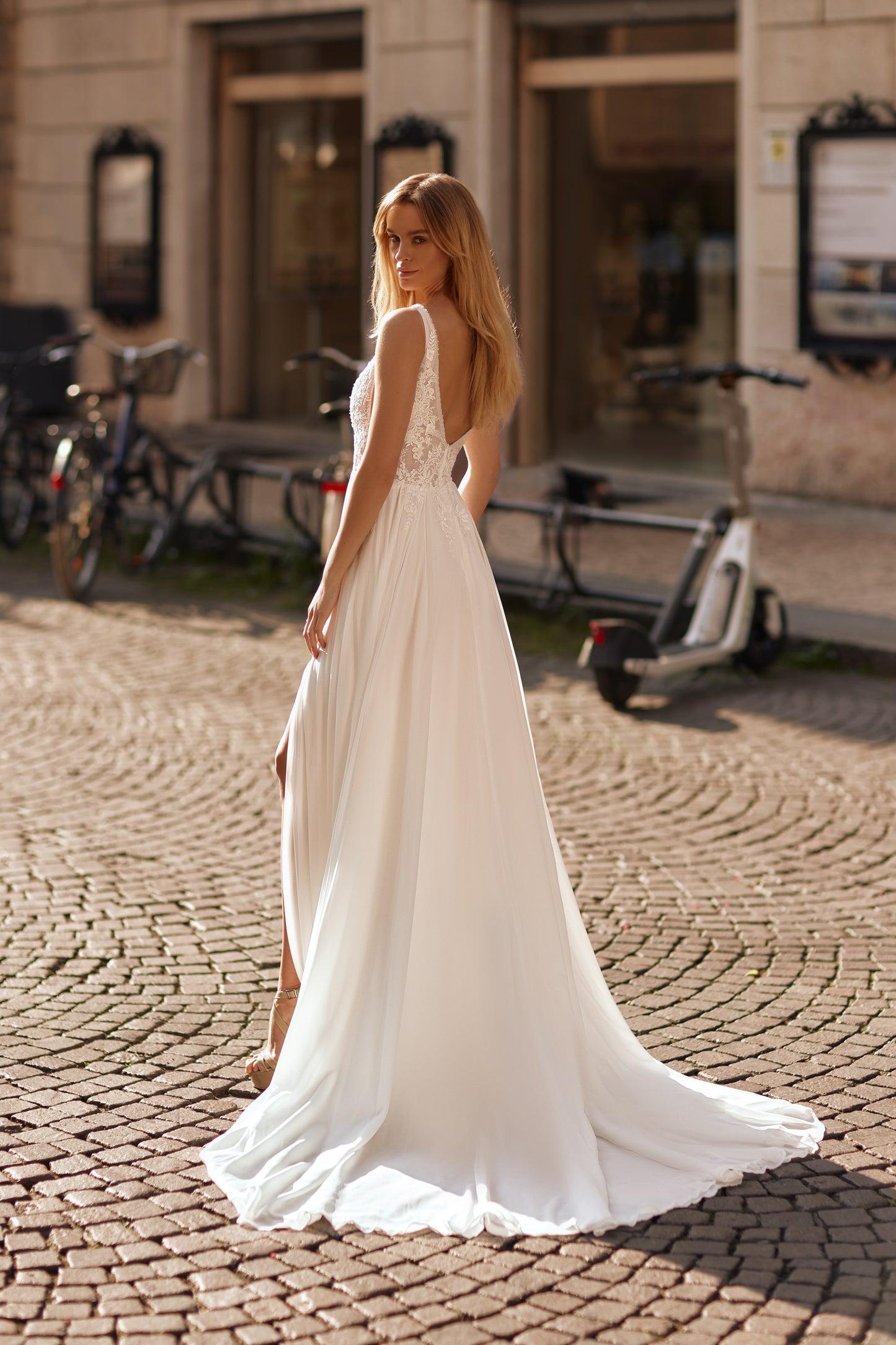 Wedding dress with delicate lace, open back, and two leg-baring slits