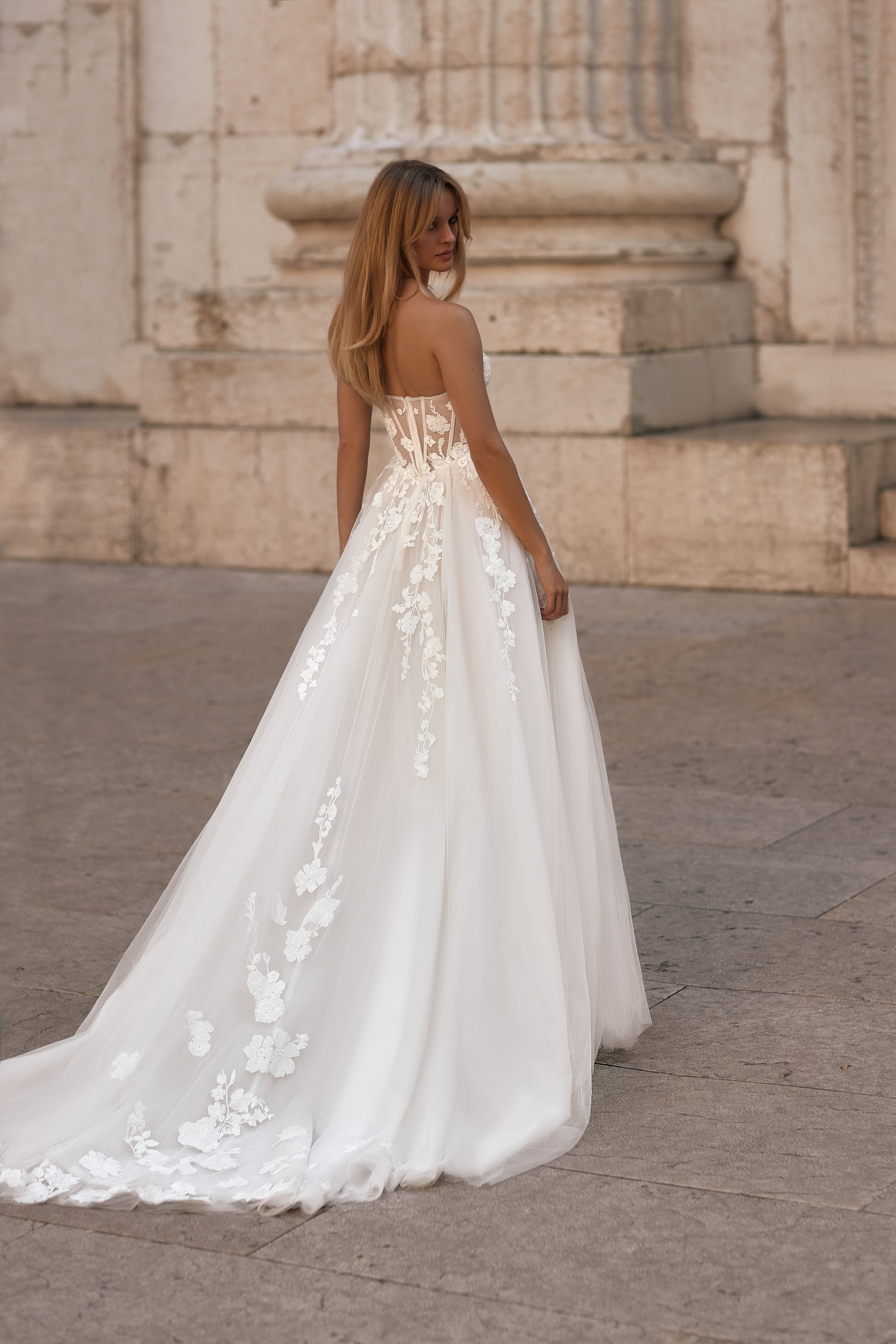Elegant gown with fitted corset, floral lace details, and sheer transparent sleeves