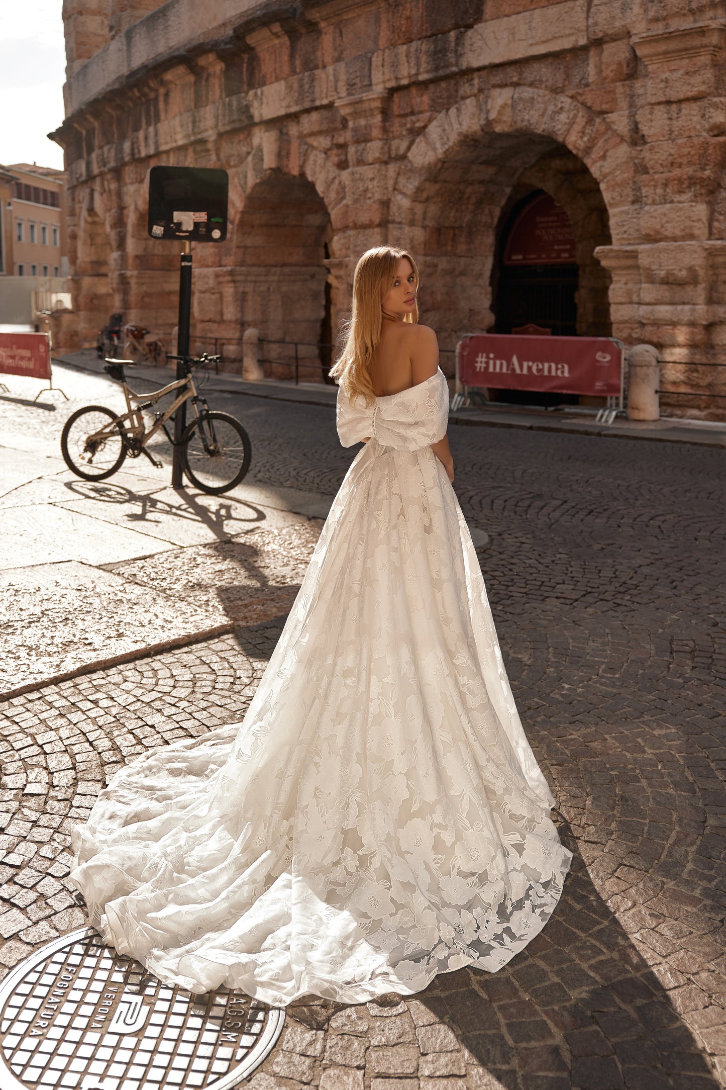 Side-back view of the Jane dress capturing the volume of the train and textured floral pattern.