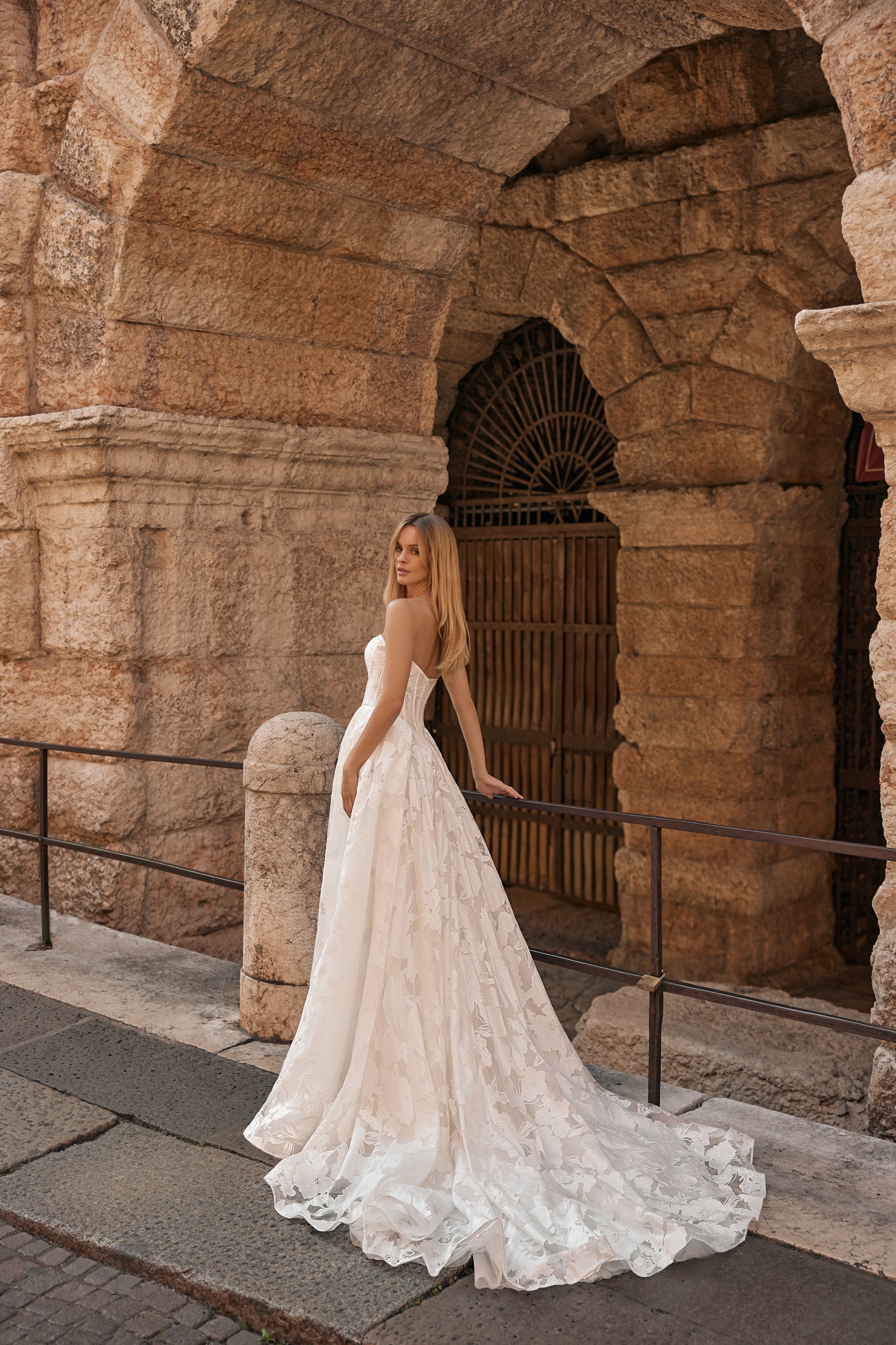 Back view of the Jane gown showing a long, flowing train with intricate floral lace details.