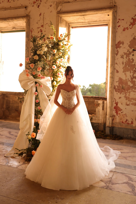 Bride in ball gown with floral lace bodice and full tulle skirt in glowing light