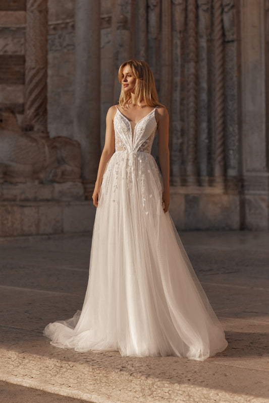 Bride in airy tulle gown with floral corset and flowing A-line skirt