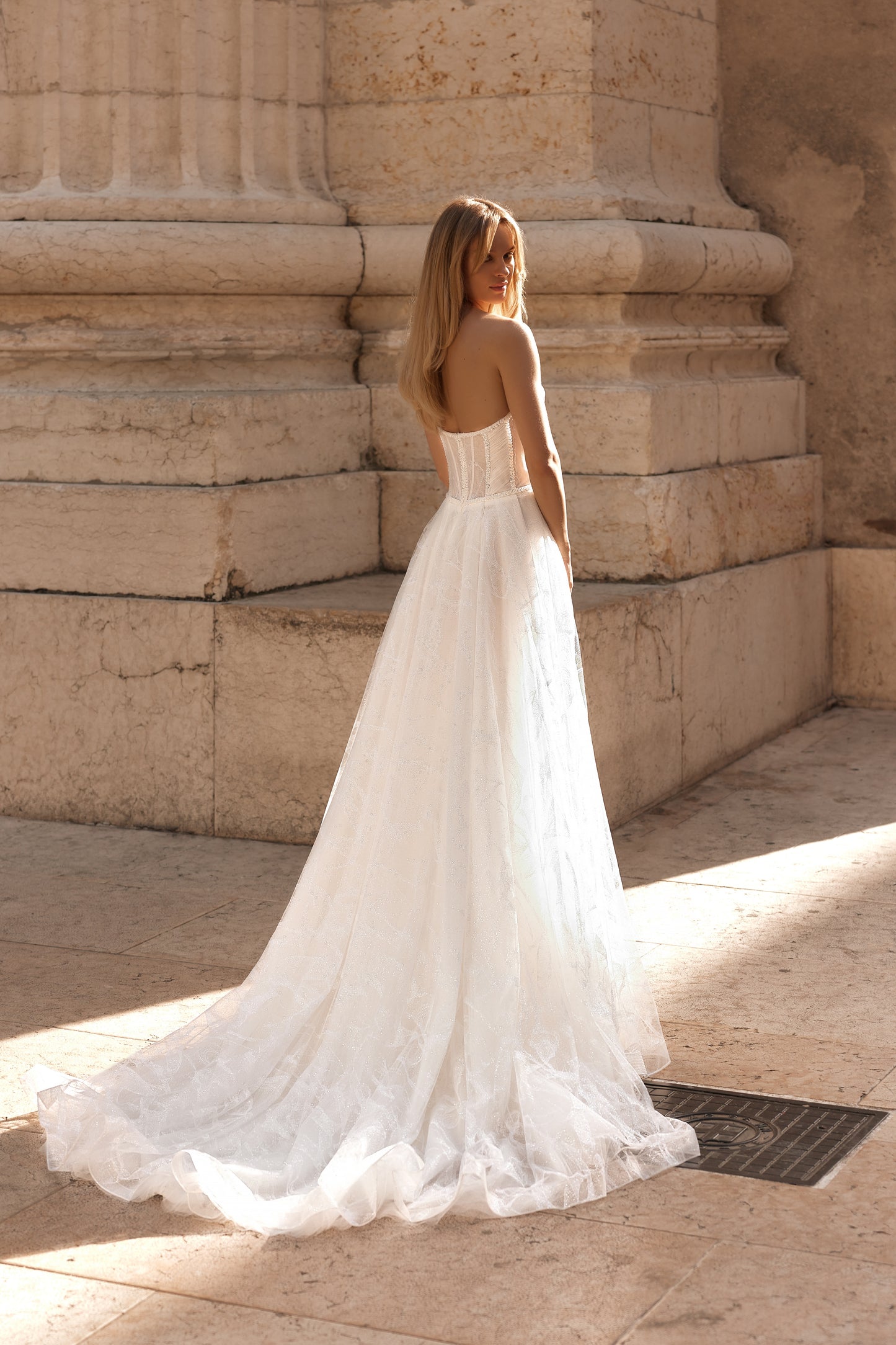 Wedding dress with romantic sheer panels, fitted bodice, and long flowing train