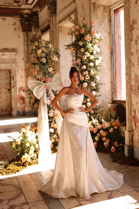 Bride in shimmering lace gown with detachable sleeves and satin overskirt