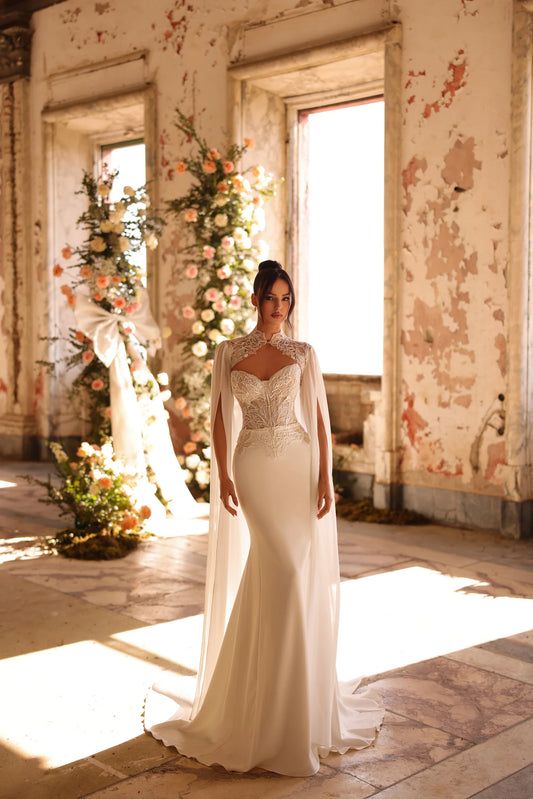 Bride in sleek wedding gown with sheer embroidered bodice and soft train