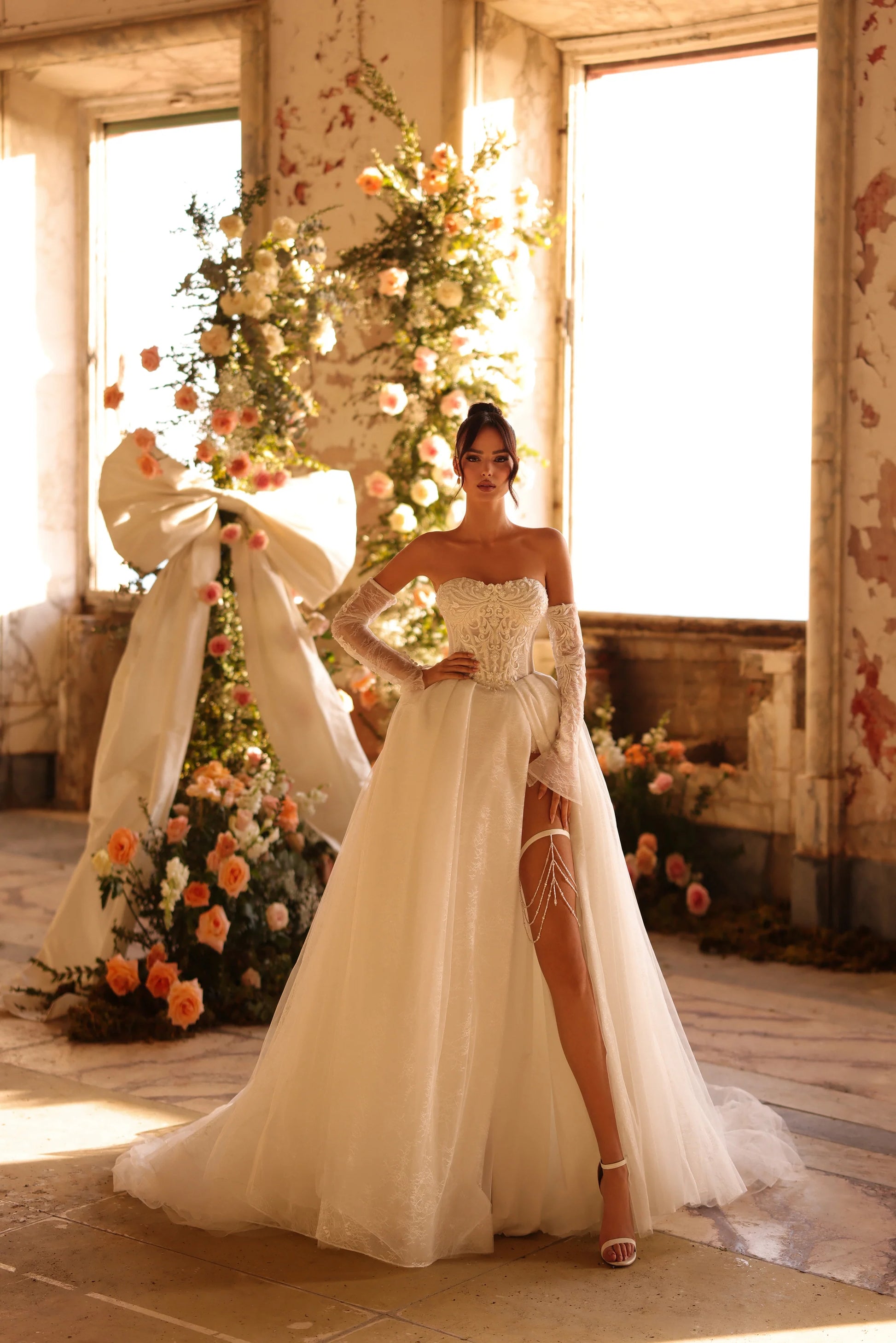 Bride in fairytale wedding gown with leg slit and elegant floral backdrop