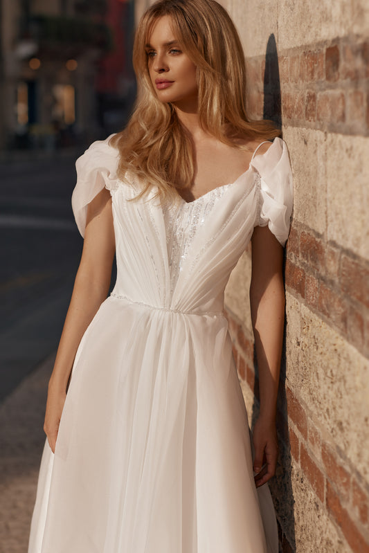 Bride in soft tulle wedding gown with shimmering sequins, puff sleeves, and a full skirt