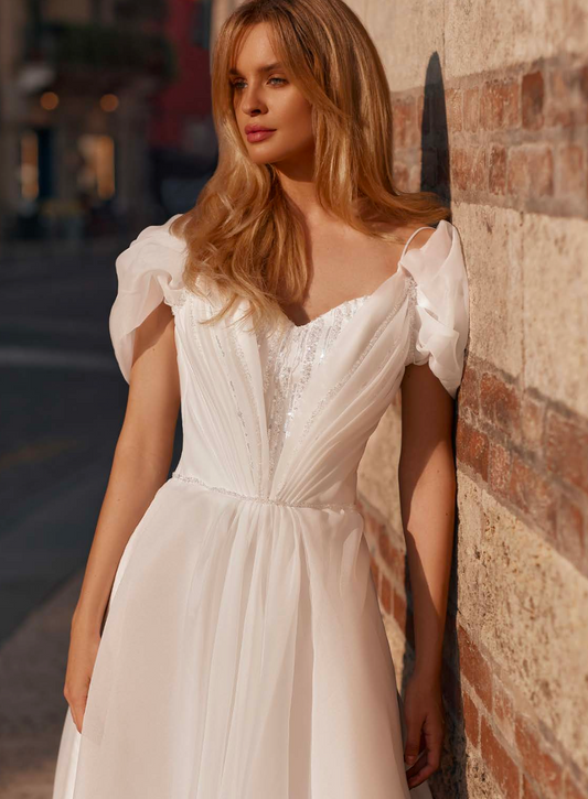 Bride in soft tulle wedding gown with shimmering sequins, puff sleeves, and a full skirt