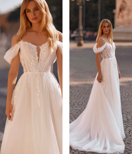 Bride in off-shoulder wedding gown with floral bodice and sheer skirt details