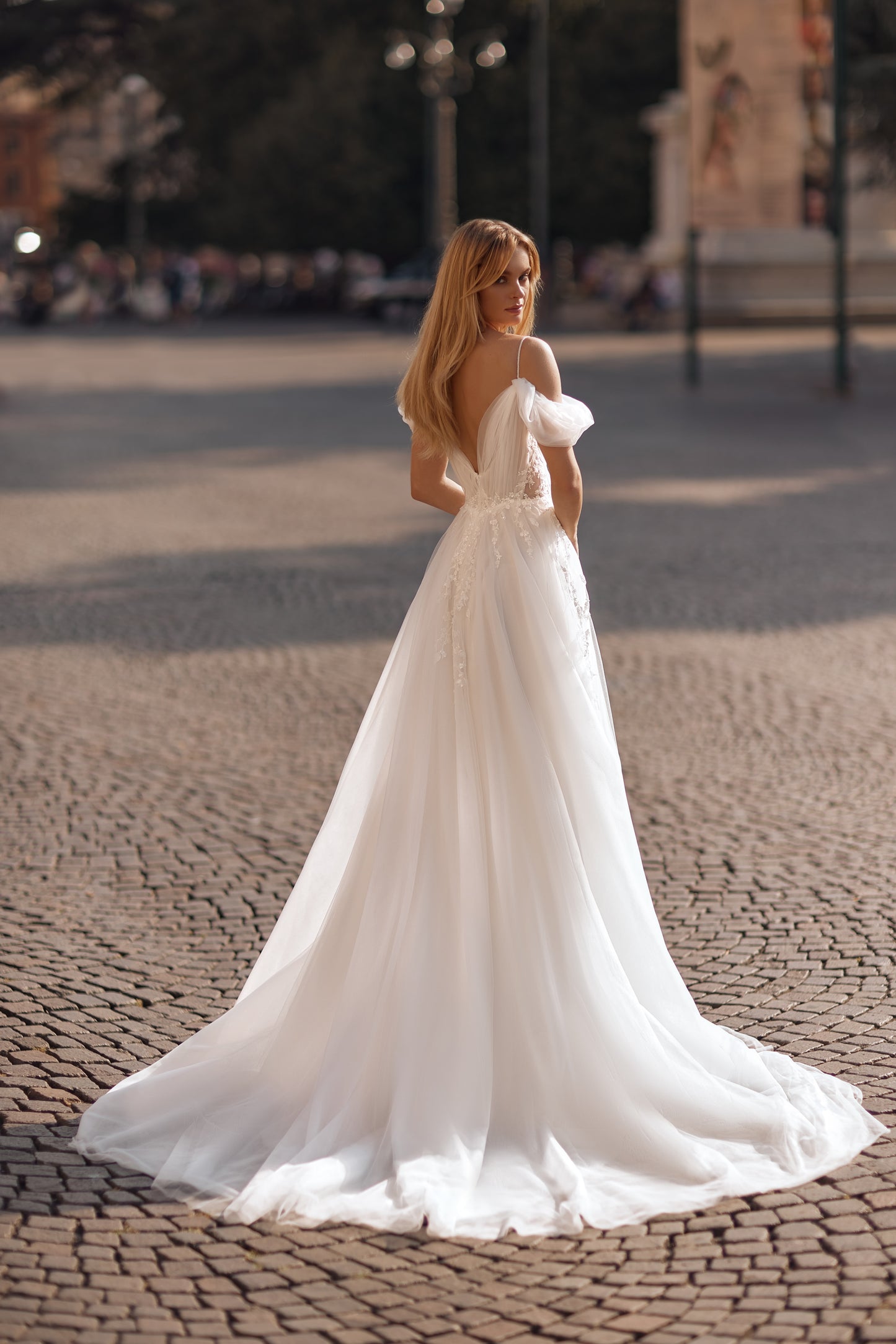 Wedding dress with floral bodice, sheer panels, and elegant long train