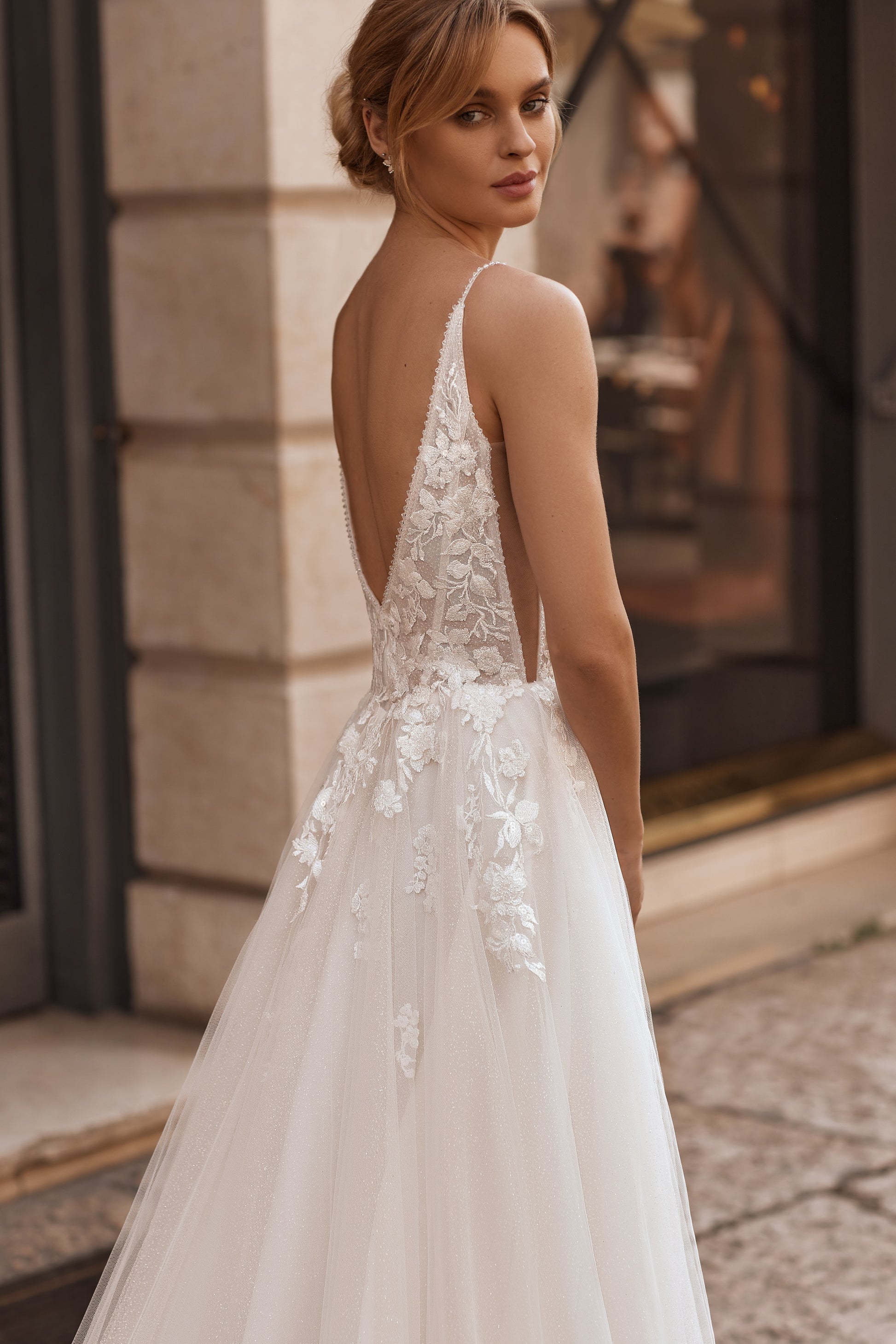 Flowy tulle skirt and open back design with soft layered silhouette