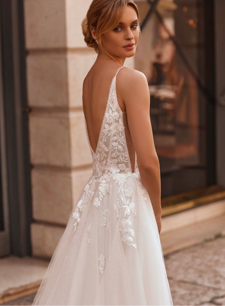 Flowy tulle skirt and open back design with soft layered silhouette