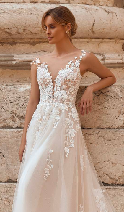 Bride in sheer lace wedding gown with illusion bodice and floral embroidery
