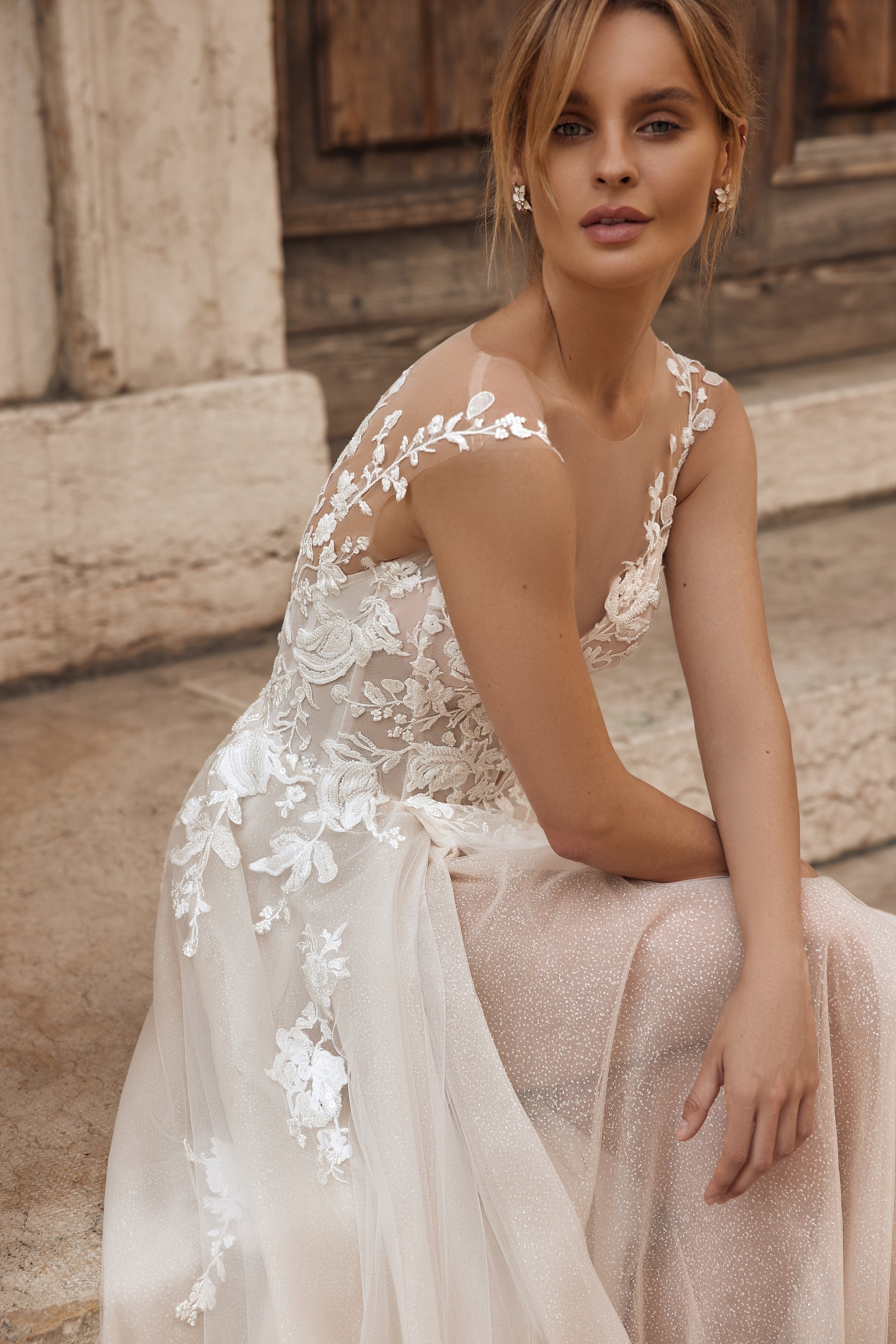 Bride in sheer lace wedding gown with illusion bodice and floral embroidery