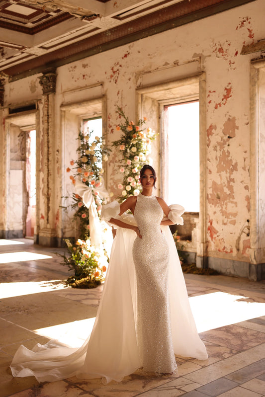 Bride in glittering sheath gown with detachable overskirt in rustic venue
